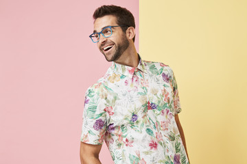 Glasses guy in floral shirt laughing and looking away