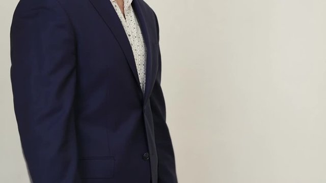 Businessman stands and gesticulation by hands.