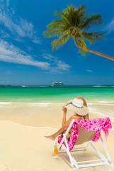 Woman sitting on a chair at the beach