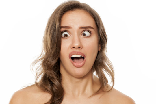 Portrait of beautiful young woman making funny faces on white background