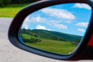The view to the beautiful land through mirror of car