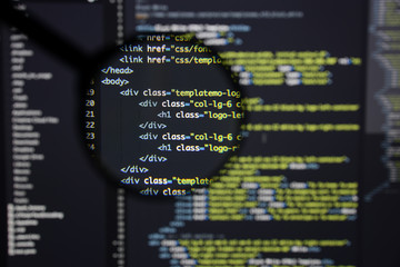 Real Html code developing screen. Programing workflow abstract algorithm concept. Lines of Html code visible under magnifying lens.
