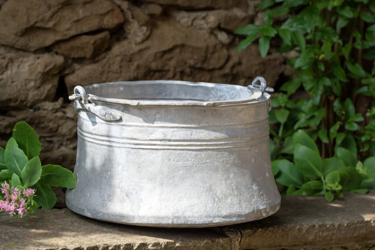 Old metal water container in the garden- traditional Bulgarian copper water container (bakir). Used to bring water from the well.