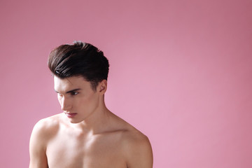 Naklejka premium Attractive naked male standing over pink background