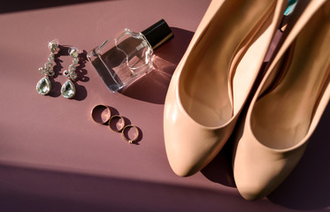 Wedding accessories, selective focus. Bridal shoes, earrings, perfume bottle, three wedding and...