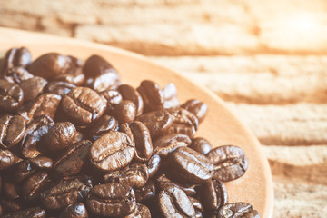 Close up of coffee beans on wooden spoon.