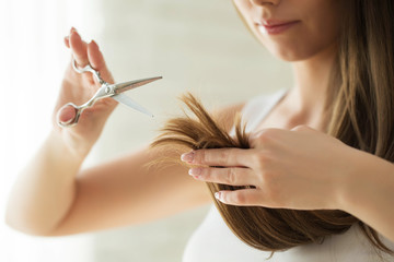 A woman is cutting her hair 