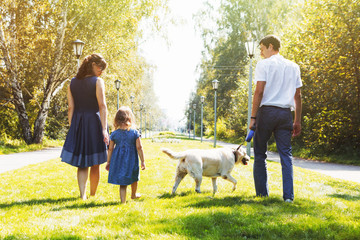 Obraz premium Happy family with dog walking in the Park