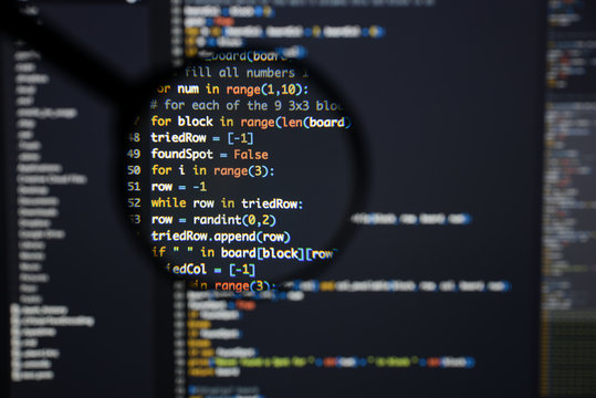 Real Python code developing screen. Programing workflow abstract algorithm concept. Lines of Python code visible under magnifying lens.