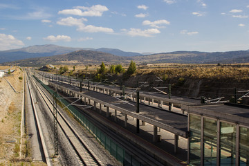 Obraz premium Outdoor railway station with mountains and blue sky background