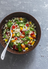 Israeli cous cous ptitim vegetables tabbouleh salad on a gray background, top view. Vegetarian food concept