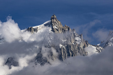 Fototapeta na wymiar Aiguille du Midi among the clouds. Mont Blanc massif. Alps.