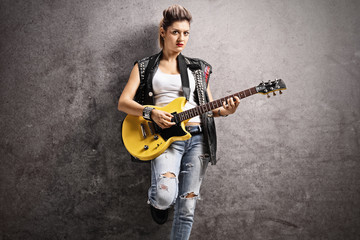 Female punker playing an electric guitar