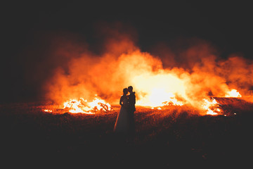 Amazing wedding couple near the fire at night