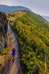 Obraz premium Cycling, mountain bikeing woman on cycle trail in autumn forest. Mountain biking in autumn landscape forest. Woman cycling MTB flow uphill trail.