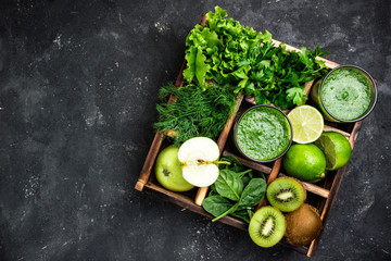 Green smoothie with ingredients on dark concrete table. Healthy  smoothie cocktail with fruits, vegetables and hebs. Healthy food and diet concept. Top view, copy space