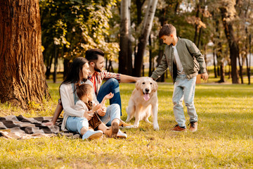 Family playing with dog in park