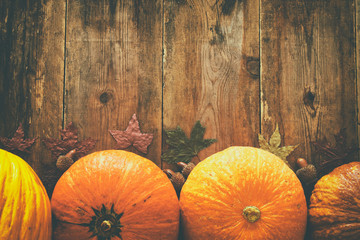 Pumpkins and autumn leaves on wooden background. thanksgiving and halloween concept. Top view