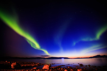 Naklejka na ściany i meble Beautiful picture of massive multicolored green vibrant Aurora Borealis, Aurora Polaris, also know as Northern Lights in the night sky over Norway, Scandinavia