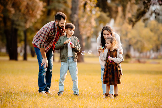 Family blowing soap bubbles - Powered by Adobe