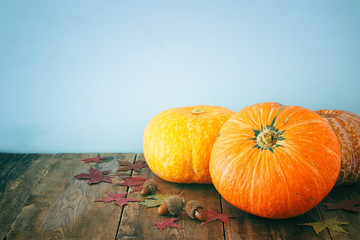 Pumpkins and autumn leaves on wooden background. thanksgiving and halloween concept