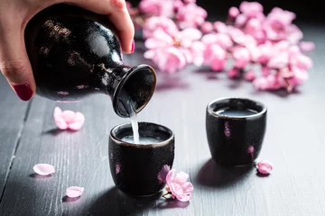 Foto op Plexiglas anti-reflex Ready to drink sake with flowers of blooming cherry © shaiith