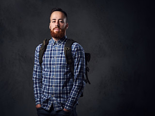 A man dressed in a fleece shirt with a backpack on his shoulder.