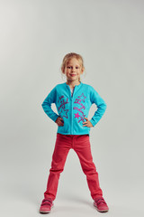 Full length portrait of fashionable little model in casual clothes posing in studio. 