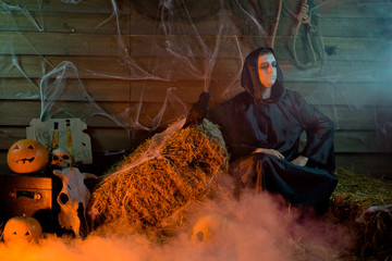 Halloween male sorcerer, black crow, skull, pumpkin straw, witchcraft
