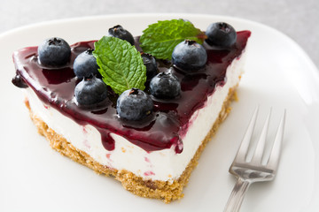 Piece of blueberry cheesecake on gray stone