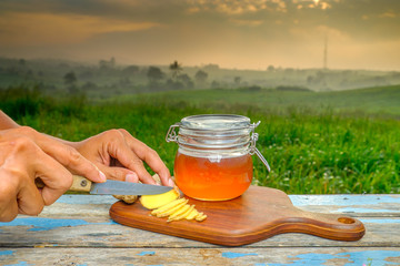 Alternative Medicine with garlic and  honey on wooden table. Beautiful sunrise as background.