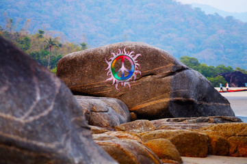 Anarchy sign on the rock. Palolem beach. Colorful draw.