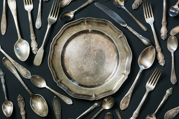 Plate, spoons, forks, knives, silverware pattern on black background. Kitchen texture. - obrazy, fototapety, plakaty