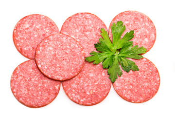 Smoked salami sausage. Sliced smoked sausage salami isolated on white background. Pieces of smoked sausage decorated with parsley leaves. Neatly sliced smoked sausage for advertising. Space for text.
