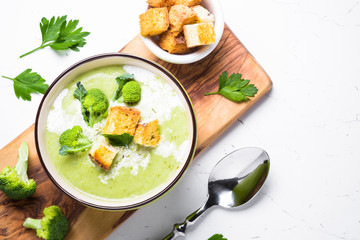 Green soup puree with broccoli on white. Top view copy space.