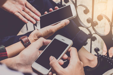 Close up of men and  woman hands holding touching mobile phone with blank copy space for your text message in cafe  with light Sunset,Vintage tone.Selective focus
