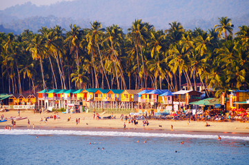 Palolem beach, South Goa, India. One of the best beaches in Goa. Colorful beach huts and palm trees on the coast. Luxury leisure. - obrazy, fototapety, plakaty