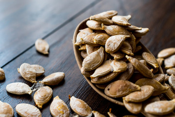 Pumpkin seeds in wooden spoon.