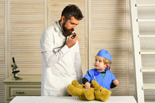 Man with beard and boy talk into stethoscope