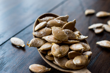 Pumpkin seeds in wooden spoon.