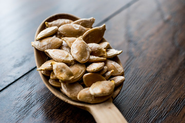 Pumpkin seeds in wooden spoon.