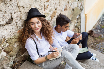 Two young tourists with smartphone in the old town.