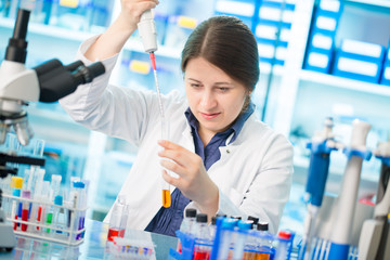 Girl laboratory assistant in the chemical laboratory of the university experiment with chemical...
