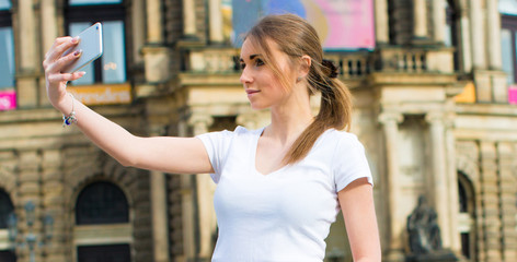 Girl makes photos shots of european city Dresden and selfie of background old German town