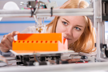 A female student or laboratory assistant in the automation laboratory is debugging the work of the...