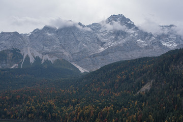 Fototapeta premium misty and cloudy mountains and autumn trees in Bavaria near Zugspitze