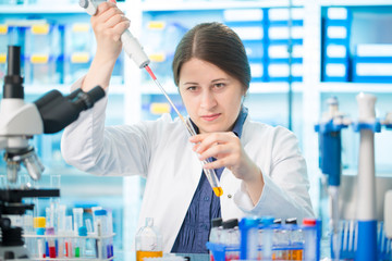 Girl laboratory assistant in the chemical laboratory of the university experiment with chemical...