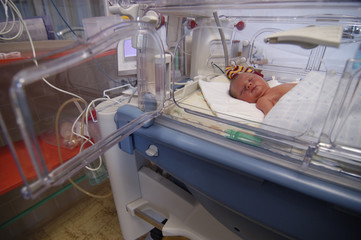 Newborn child baby sleeping in incubator. A neonatal intensive care unit (NICU), intensive care nursery (ICN) for premature newborn infants © Petr Bonek