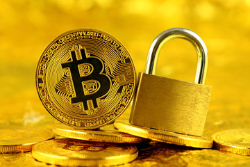 Physical version of Bitcoin (new virtual money) and golden padlock. Conceptual image for money and...