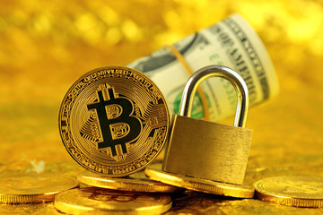 Physical version of Bitcoin (new virtual money) and golden padlock. Conceptual image for money and...